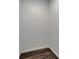 Walk-in closet featuring wood-look flooring and white walls at 6097 Vermont Ave, New Port Richey, FL 34653