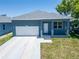 Charming home showcasing a well-maintained front yard, a garage, and a freshly painted blue exterior at 6097 Vermont Ave, New Port Richey, FL 34653