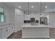 Kitchen features white cabinetry, a center island with pendant lights, stainless steel appliances, and modern finishes at 6097 Vermont Ave, New Port Richey, FL 34653