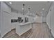Open-concept kitchen and living area with a center island, stainless steel appliances, ceiling fans, and wood-look floors at 6097 Vermont Ave, New Port Richey, FL 34653