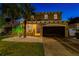 Two-story home featuring a front yard with palm trees and white rock landscaping, plus a two-car garage at 7705 S Sparkman St, Tampa, FL 33616