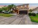 Two story home with stucco exterior, two-car garage, and manicured landscaping at 7705 S Sparkman St, Tampa, FL 33616