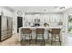 Bright kitchen featuring white cabinetry, a large island with seating, and stainless steel appliances at 7705 S Sparkman St, Tampa, FL 33616