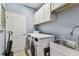 Laundry room with new appliances, utility sink, and storage cabinets at 7705 S Sparkman St, Tampa, FL 33616