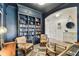 Office features a built-in library, two chairs, wood flooring, and an entryway into the foyer at 7705 S Sparkman St, Tampa, FL 33616