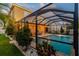 Outdoor, screened pool with travertine deck, outdoor lights, and mature landscaping at 7705 S Sparkman St, Tampa, FL 33616