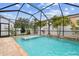 Screened pool featuring clear blue water, rock waterfall, and easy access steps at 7705 S Sparkman St, Tampa, FL 33616