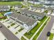Aerial view of the community featuring townhomes with garages, landscaping, and well-maintained streets at 7709 Imagination Pl, Wesley Chapel, FL 33545