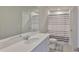 Modern bathroom with a vanity, mirror, and shower featuring an attractive striped curtain at 7709 Imagination Pl, Wesley Chapel, FL 33545