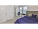 Well-lit bedroom features a bed, desk, closet, and large windows at 7709 Imagination Pl, Wesley Chapel, FL 33545