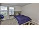 Well-lit bedroom features a bed, large windows, desk, and comfortable rolling chair at 7709 Imagination Pl, Wesley Chapel, FL 33545