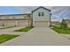 Charming townhome featuring a light blue accent above the garage and a well-manicured lawn at 7709 Imagination Pl, Wesley Chapel, FL 33545