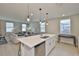 Open-concept kitchen with a large island, stainless steel dishwasher, and sightlines to the living room at 7709 Imagination Pl, Wesley Chapel, FL 33545