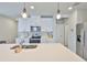 Well-lit kitchen with stainless steel appliances, white cabinets, and an island with sink at 7709 Imagination Pl, Wesley Chapel, FL 33545