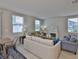 Bright living room featuring a fireplace, comfortable seating, and large windows at 7709 Imagination Pl, Wesley Chapel, FL 33545