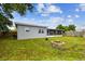 A spacious backyard with a fire pit, screen enclosure, swing set, and well-maintained lawn at 8528 Iris Ave, Seminole, FL 33777