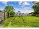 Fenced backyard featuring a classic wooden swing set and lush green lawn at 8528 Iris Ave, Seminole, FL 33777