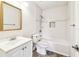 Clean bathroom with white subway tile, tub, and a gold-framed mirror at 8528 Iris Ave, Seminole, FL 33777