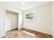 A bright bedroom featuring wood-look floors, a closet, and natural light at 8528 Iris Ave, Seminole, FL 33777