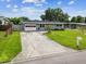 Charming single-story home with a well-maintained lawn and a long concrete driveway at 8528 Iris Ave, Seminole, FL 33777