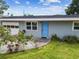 Charming home exterior with light blue accents, a well-kept lawn, and a walkway to the front door at 8528 Iris Ave, Seminole, FL 33777