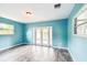 Bright room with light blue walls, wood-look floors, and glass doors leading to the outside area at 8528 Iris Ave, Seminole, FL 33777