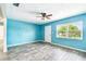 Bright living area featuring a large window, wood-look floors, and freshly painted light blue walls at 8528 Iris Ave, Seminole, FL 33777