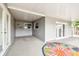 Covered patio with concrete floor, windows, double doors, and colorful flower rug at 8528 Iris Ave, Seminole, FL 33777