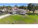 An aerial view of this home, showcasing a well-kept lawn, concrete driveway, and a neutral color scheme at 9416 Bullfrog Court, Gibsonton, FL 33534