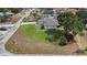 Bird's-eye view of the home on a spacious corner lot, featuring a large green lawn and a concrete driveway at 9416 Bullfrog Court, Gibsonton, FL 33534