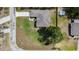 Aerial view showcasing the home's roof, concrete driveway, and corner lot featuring a large green lawn at 9416 Bullfrog Court, Gibsonton, FL 33534