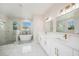 Bathroom featuring a walk-in shower, soaking tub, double vanity, and modern fixtures at 9416 Bullfrog Court, Gibsonton, FL 33534