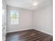 Cozy bedroom with dark wood floors, a ceiling fan, and a bright window view at 9416 Bullfrog Court, Gibsonton, FL 33534