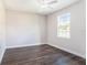 This bedroom features dark wood-look floors, white trim, a ceiling fan, and a bright window at 9416 Bullfrog Court, Gibsonton, FL 33534