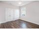 Bedroom featuring white walls, wood-look flooring, and a double-door closet at 9416 Bullfrog Court, Gibsonton, FL 33534