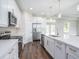 Modern kitchen features white cabinets, stainless steel appliances, and a large center island at 9416 Bullfrog Court, Gibsonton, FL 33534