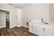 Laundry room with storage cabinets, a sink, and wood-look flooring at 9416 Bullfrog Court, Gibsonton, FL 33534