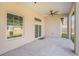 This covered patio includes a ceiling fan and views of the backyard at 9416 Bullfrog Court, Gibsonton, FL 33534