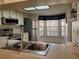 Bright kitchen with stainless steel appliances, white cabinets, and a large window at 946 Madrid Dr, Palm Harbor, FL 34684