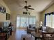 Comfortable living room with sliding door access, ceiling fan, and entertainment center at 946 Madrid Dr, Palm Harbor, FL 34684