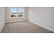 Bedroom with carpet flooring and dual windows offering views of the surrounding area at 9955 Surrey Rose Dr, San Antonio, FL 33576