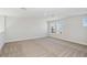 Bedroom with neutral carpet, recessed lighting, and double windows looking out at a new home community at 9961 Surrey Rose Dr, San Antonio, FL 33576