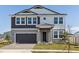 Two-story home featuring a two-car garage, a manicured lawn, and a well-maintained exterior at 9961 Surrey Rose Dr, San Antonio, FL 33576