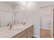 A modern bathroom with double vanity, quartz countertop and a framed mirror at 9989 Surrey Rose Dr, San Antonio, FL 33576