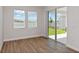 Bedroom features wood-look flooring, neutral walls, and sliding glass door to a patio at 9989 Surrey Rose Dr, San Antonio, FL 33576