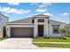 Charming single-Gathering home featuring a two-car garage, neutral colors, and manicured landscaping at 9989 Surrey Rose Dr, San Antonio, FL 33576
