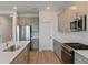 Beautiful kitchen features stainless steel appliances, quartz countertops, and wood-look flooring at 9989 Surrey Rose Dr, San Antonio, FL 33576