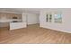 Bright and open-concept living space with a kitchen view and wood-look flooring at 9989 Surrey Rose Dr, San Antonio, FL 33576