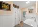 Full bathroom featuring shower, vanity, framed art, and wainscotting at 1001 E Crawford St, Tampa, FL 33604