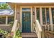 Charming home exterior featuring a green front door, wooden stairs, and garden at 1001 E Crawford St, Tampa, FL 33604